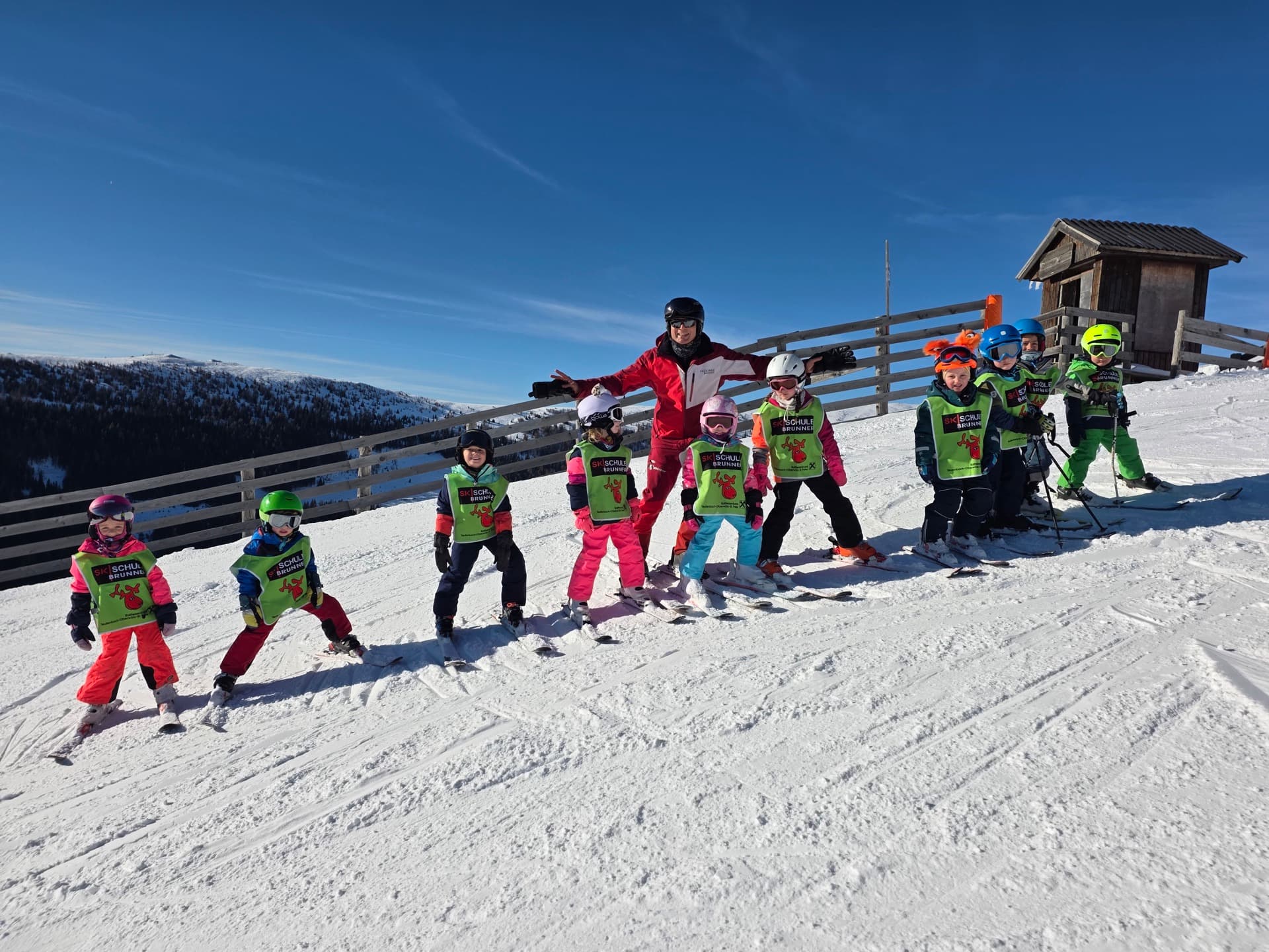 Kindergruppe in Lernwesten mit Skilehrerin der Skischule Brunner auf der Piste am Lachtal